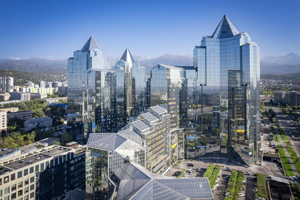 Glass office towers with mountains in the background